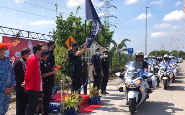 Shafien (tengah) mengangkat bendera Polis Diraja Malaysia (PDRM) sebagai simbolik perasmian Majlis Pelancaran Op Selamat 17/2022 Sempena Perayaan Tahun Baru Cina di Tunjong, Kota Bharu pada Khamis.