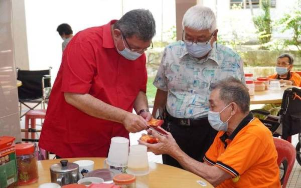 Saifuddin (kanan) menyantuni komuniti cina di pusat gabungan Persatuan Tiong Hua di Bukit Ubi di sini pada Jumaat.