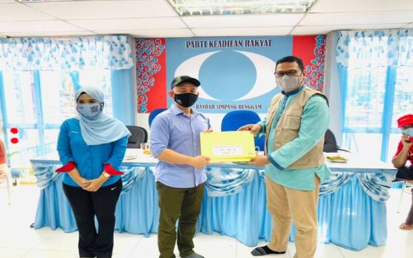 Maszlee (tengah) menyampaikan watikah kepada salah seorang Ketua PDM jentera PH pada majlis berkenaan, pada Jumaat.