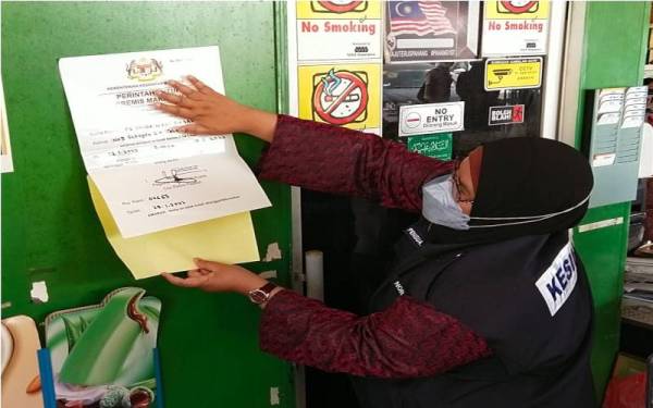 Dr Nor Azimi menampal notis arahan tutup ke atas sebuah premis makanan dalam Operasi Penguatkuasaan Bersepadu Mega PPKHT 2004, Akta 342 dan Akta Makanan 1983 Peringkat JKNP, pada Jumaat.