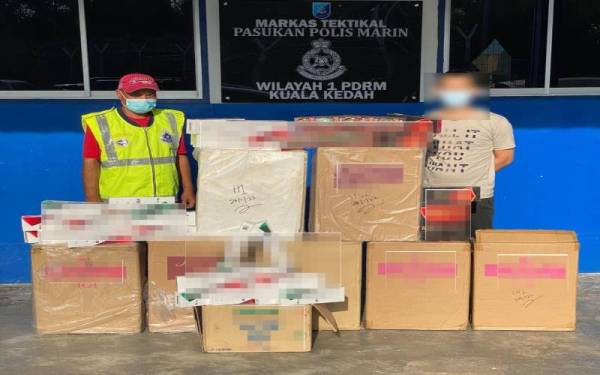 Lelaki berusia 33 tahun (kanan) yang ditahan bersama 393 karton rokok seludup direman untuk siasatan lanjut. Foto: Polis Marin