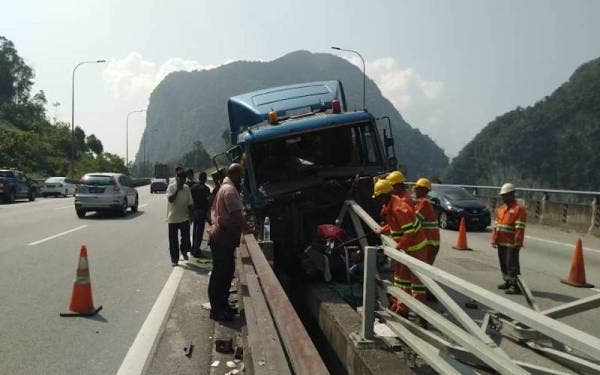 Treler muatan tiang konkrit tersangkut pada pembahagi lebuh raya menyebabkan kesesakan lebih 40km di Kampar. - Foto ihsan pembaca