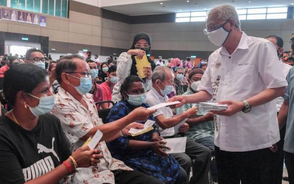 Ismail Sabri menyampaikan sumbangan kepada penerima bantuan pada Majlis Penyerahan Wang Bantuan Pembelian Barangan Keperluan MTL 2021/2022 Daerah Bera di sini hari ini. Foto Bernama