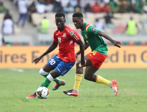 Pemain Gambia, Musa Barrow (kiri) cuba mengekang asakan pemain Cameroon Samuel Yves Gouet pada aksi berkenaan. - Foto EPA
