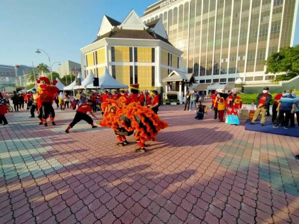 Rumaizi (kanan) menyaksikan persembahan tarian singa ketika hadir ke program Hari Tanpa Kereta di Jalan Sultan Abdul Jalil, di sini pada Ahad.

