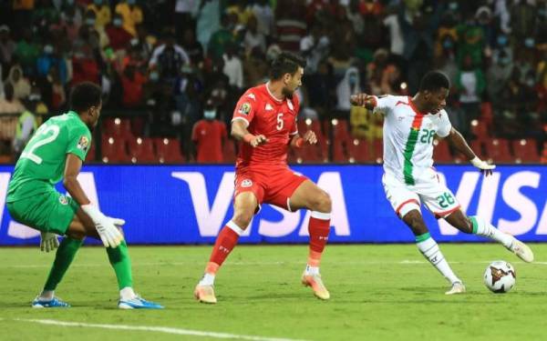 Pemain Burkina Faso, Dango Quattara (kanan), melepasi kawalan pertahanan Tunisia, sebelum merembat gol tunggal perlawanan. - foto Getty Images