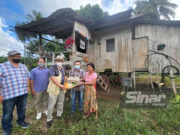 Anifah menyampaikan sumbangan kepada Rujia dalam kunjungannya di Kampung Asin-Asin, Kota Marudu.