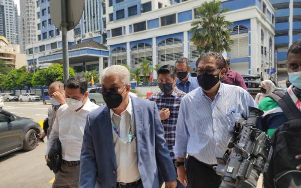 Mohammad Anuar (tengah) ditemui pemberita selepas membuat laporan polis di IPD Dang Wangi, Kuala Lumpur pada Isnin.