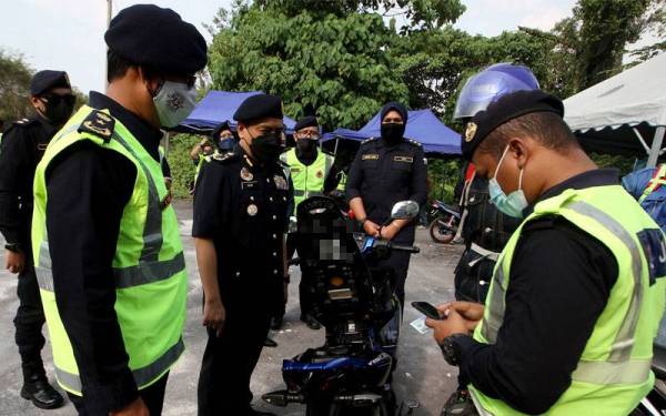 Aedy Fadly (dua,kiri) mengetuai pemeriksaan yang dilakukan terhadap pengguna jalan raya pada Op Tahun Baharu Cina 2022 Peringkat Negeri Perak di Kilometer 1, Jalan Simpang Pulai - Cameron Highlands di Simpang Pulai, pada Isnin. Hadir sama, Mohammad Yusoff Abustan (kiri). Foto Bernama