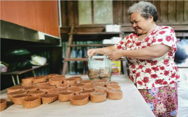 Choo Im membungkus kuih bakul yang disiapkan 10 hari lebih awal untuk dihidangkan sempena Tahun Baharu Cina.