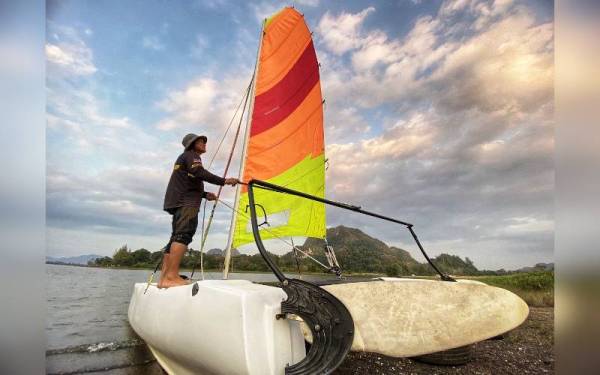 Salehhodin menunjukkan cara pengendalian perahu layar mengikut keadaan angin di Tasik Timah Tasoh pada Isnin.