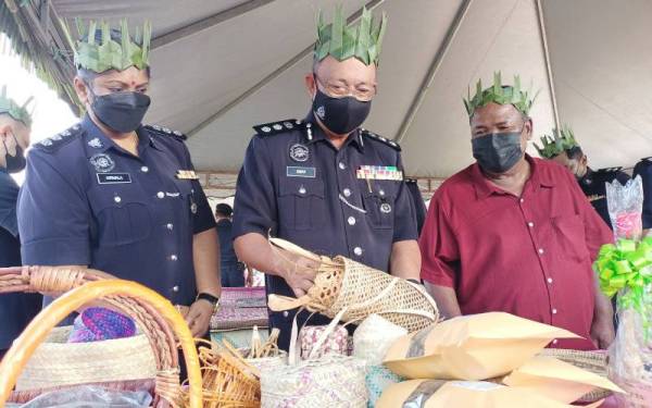 Omar Bakhtiar (tengah) bersama Tok Batin Kampung Ulu Bekor, Uda Awai Busu Kechek dan Ketua Bahagian Pencegahan Jenayah dan Keselamatan Komuniti Daerah, Asisten Superintendan A Nirmala melihat kraftangan dihasilkan penduduk orang asli yang dipamerkan sempena progran HPP.