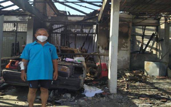 Ah Kaw berada di depan kediamannya yang turut memusnahkan perabot dibelinya dua minggu lalu dan stok pakaian jualan dalam kejadian kebakaran pada Rabu lalu.