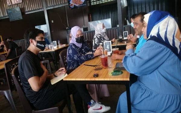 Syed Saddiq (kiri) bertemu dengan orang ramai selepas Kempen Jelajah Mendengar Sempena PRN Johor di Al-Mizan Satay House, Johor Bahru pada Jumaat.