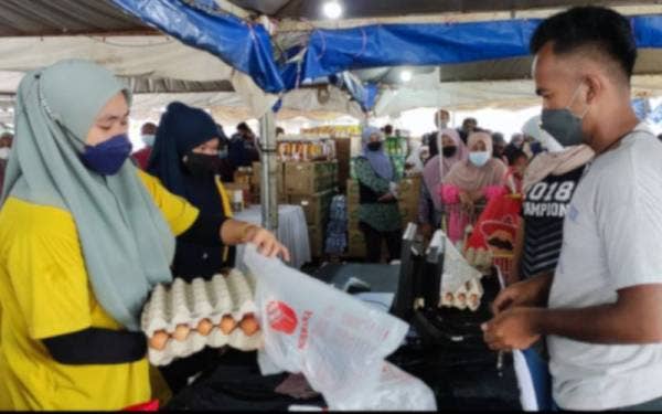 Pengunjung membeli telur pada Program Jualan Keluarga Malaysia (PJKM) di Dataran Pasar Tani, Kuala Ping, Kuala Berang pada Sabtu.