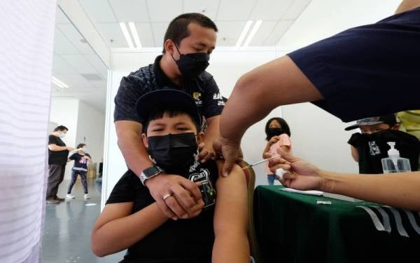 Seorang kanak-kanak menerima suntikan vaksin jenis Pfizer pada PICKids di PPV Offsite IOI City Tower 1 pada Sabtu. - Foto Bernama