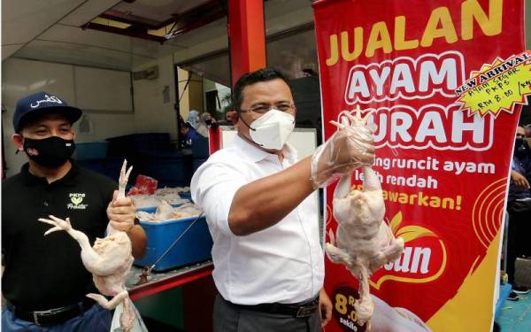 Amirudin (kanan) dan Ketua Pegawai Eksekutif Kumpulan Perbadanan Kemajuan Pertanian Selangor (PKPS), Dr Mohamad Khairil Mohamad Razi (kiri), menunjukkan ayam yang dijual dengan harga murah RM8 sekilogram ketika jualan ayam murah di Wisma PKPS Seksyen 14, Shah Alam, pada Sabtu. - Foto Bernama