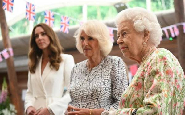 Ratu Elizabeth II (kanan) diiringi Camilla (tengah) ketika menyertai sebuah acara berhampiran St Austell di barat daya England pada Jun 2021. - Foto: AFP