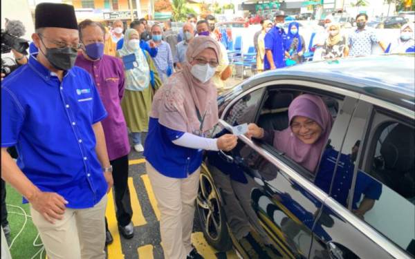 Sazrina (tengah) menyampaikan kad pandu lalu kepada Mumtaz sebagai gimik perasmian majlis berkenaan.