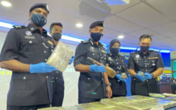 Soffian (tengah) menunjukkan ganja dan peralatan menghisap dadah yang dirampas dalam tiga serbuan pada Ahad lalu.