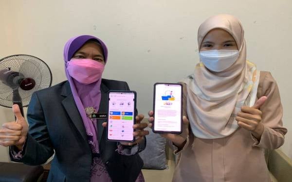 Nora (kiri) menunjukkan aplikasi Prihatin Perkeso yang boleh dimuat turun melalui telefon bimbit.