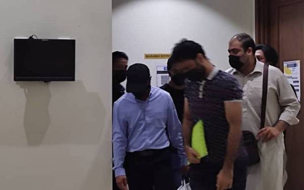 Tertuduh (kiri) ketika hadir di Mahkamah Khas Rasuah, Kota Kinabalu.