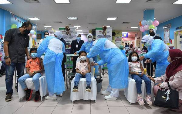 Tiga beradik Nazeef Audric Kamarul Azhar, 9, (dua, kiri) Nazriel Ariqin, 5, dan Nurlisa Maureen, 6, yang ditemani ibu bapa mereka Kamarul Azhar Zainun, 47, (kiri) dan Nor Ruziah Ismail, 46, (kanan) menerima suntikan vaksin menerusi Program Imunisasi Covid-19 Kanak-kanak (PICKids) peringkat negeri di Hospital Sultanah Nur Zahirah (HSNZ) hari ini.