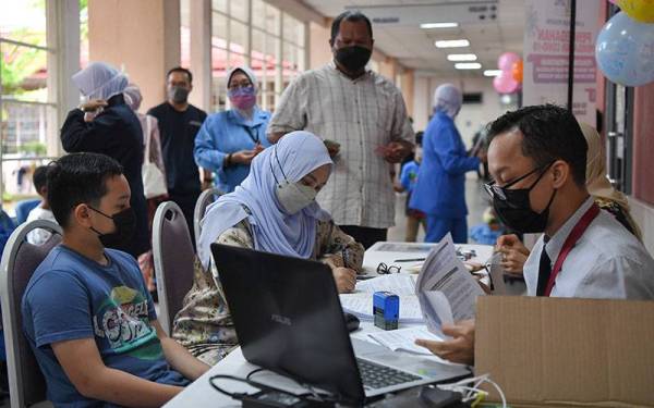 Ibu bapa mengisi borang untuk anak mereka sebelum menerima suntikan vaksin menerusi Program Imunisasi Covid-19 Kanak-kanak (PICKids) peringkat negeri di Hospital Sultanah Nur Zahirah (HSNZ) hari ini.