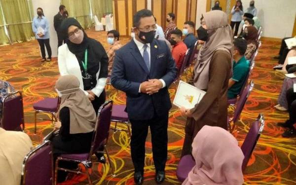 Amirudin beramah mesra dengan penerima pada Majlis Penyampaian Surat Tawaran Pinjaman Boleh Ubah Dalam Negara di Dewan Jubli Perak Sultan Abdul Aziz.