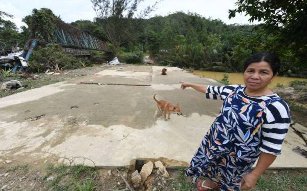 Tinggal lantai...Penduduk Kampung Pias Kanibungan Pitas, Sinupiying Mosingkat menunjukkan lantai kedai makannya yang dibawa arus deras ketika banjir di Kanibungan Ahad lepas. - Foto Bernama