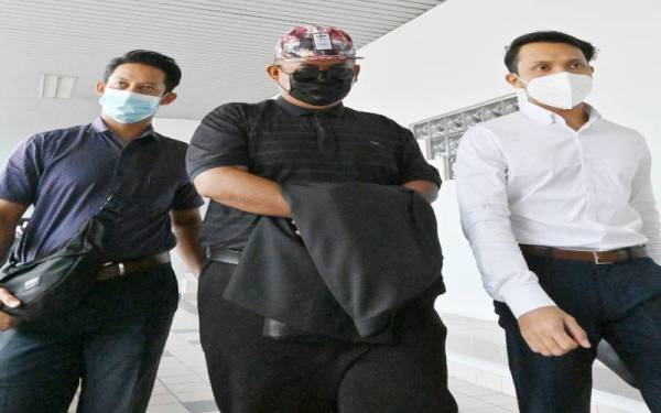 Muhammad Nurhafizi (tengah) ketika keluar dari Mahkamah Sesyen di sini, pada Rabu.