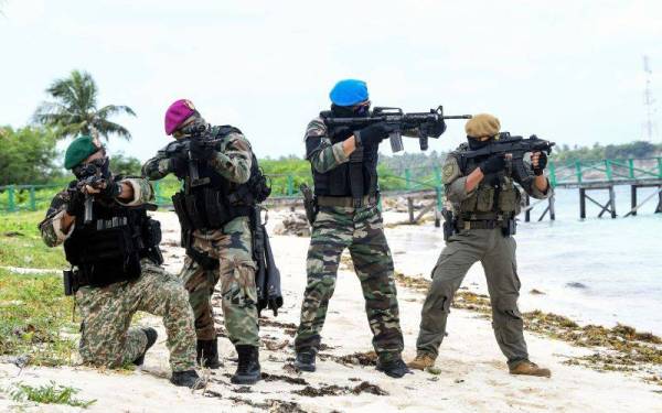 Anggota pasukan keselamatan (dari kiri) Grup Gerak Khas (GGK) Tentera Darat Malaysia, Pasukan Khas Laut (Paskal) Tentera Laut Diraja Malaysia, Pasukan Khas Udara (Paskau) Tentera Udara Diraja Malaysia dan Very Able Trooper 69 (VAT 69) Polis Diraja Malaysia membuat rondaan di pesisir pantai Pulau Siamil pada Rabu. - FotoBernama