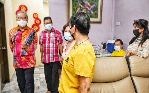 Chin Chye (dua,kiri) menerima kunjungan Mohd Ali ketika sambutan Tahun Baharu Cina di kediaman kelurganya di Bukit Beruang, baru-baru ini.