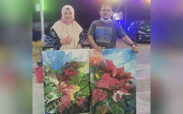 Cikgu Mohd Saribunis bersama salah seorang peminat tanaman keladi yang membeli hasil lukisannya.