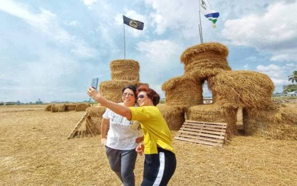 Mary Ooi (kiri) teruja bergambar bersama rakannya di Pesta Jerami Gulung Castle di Ulu Sedaka di sini pada Khamis