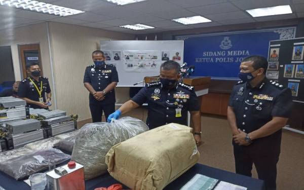 Kamarul Zaman menunjukkan dadah yang dirampas daripada sindiket yang menggunakan kurier pada sidang akhbar di IPK Khamis.