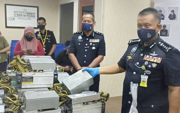 Kamarul Zaman (kanan) menunjukkan peralatan digunakan sindiket perlombongan bitcoin untuk mencuri bekalan elektrik.