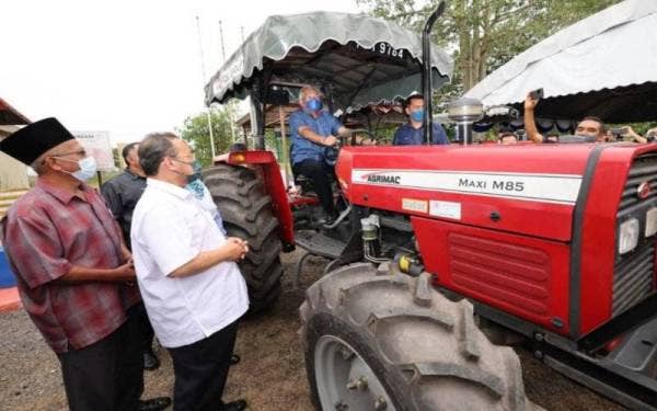 Mahadzir menguji jentera sebagai simbolik penyerahan jentera tani Koperasi Desa Cemerlang Air Melintas Besar, Kepala Batas Berhad pada Jumaat.