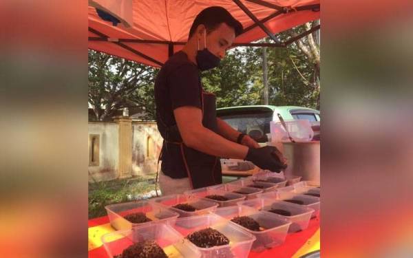 Mohd Fikrie menyediakan pesanan pelanggan di gerai mereka di Mergong pada Jumaat.