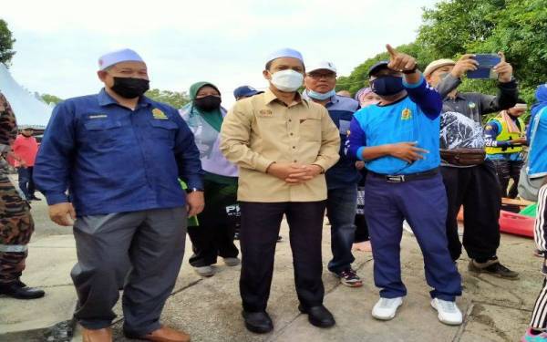 Mohd Amin (kanan) memberi penerangan kepada Sabri (tengah) ketika hadir ke Eksplorasi Berkayak Sungai Merbok@Jerai Geopark 2022 di Kompleks Pelancongan Jeti Sungai Merbok, Semeling pada Sabtu.