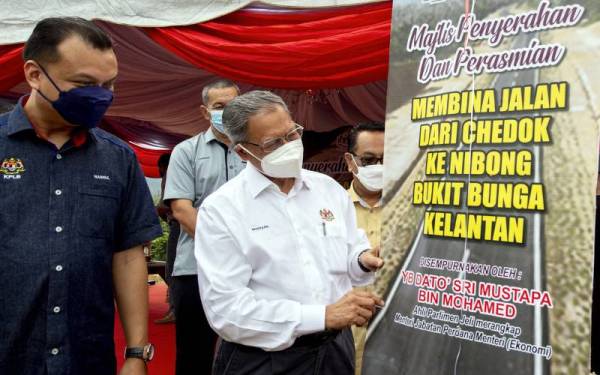 Mustapa (kanan) menyempurnakan gimik perasmian majlis penyerahan dan perasmian projek membina jalan dari Chedok ke Nibong Bukit Bunga hari ini. - Foto Bernama