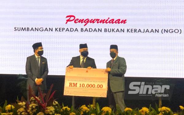 Tengku Mohamad Rizam (tengah) menyampaikan sumbangan RM10,000 kepada Pengerusi Persatuan Generasiku Sayang, Datuk Dr Zaini Hussin (kanan). - Foto Sinar Harian