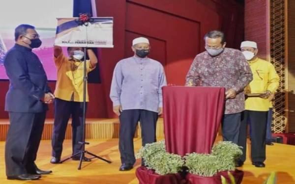 Mohd Nor (tengah) mengiringi Ahmad Samsuri menyempurnakan perasmian Program Halaqah Darul Iman (HaDI) yang disempurnakan Menteri Besar, Datuk Seri Dr Ahmad Samsuri Mokhtar di Dewan Besar Wisma Darul Iman di sini pada Isnin.