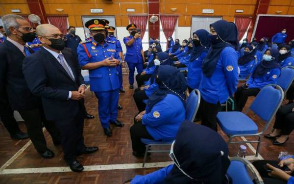 Ronald (kiri) beramah mesra dengan anggota CDERT FAMA pada majlis Pelancaran Penubuhan CDERT FAMA dan Penyampaian Watikah Pelantikan Pegawai Bersekutu APM di Institut Latihan FAMA pada Selasa.