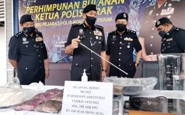 Mior Faridalathrash (dua dari kiri) menunjukkan dadah dan alat memproses bahan terlarang yang dirampas dalam serbuan di sebuah rumah sewa yang dijadikan makmal dadah di Meru Raya pada Ahad lalu.