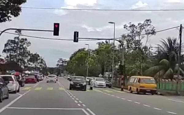 Tangkap layar video yang tular pada Selasa memaparkan pemandu Perodua Myvi melanggar lampu isyarat sehingga nyaris merempuh seorang murid di depan SK Seri Budiman di Kuala Terengganu.