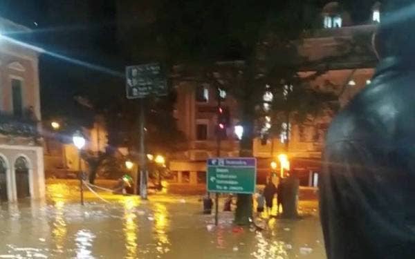 Orang ramai berdiri di jalan yang dinaiki air di Petropolis, Brazil. - Foto Lucas Mariano/Reuters
