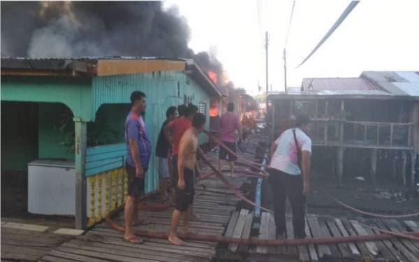 Penduduk bertungkus-lumus membantu memadamkan kebakaran di perkampungan Kampung Landung Ayang, Kudat.