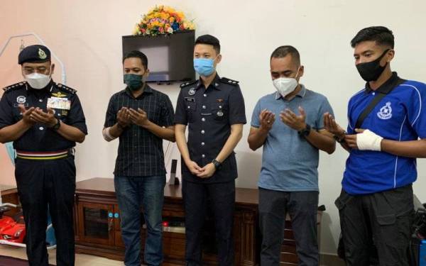 Shafien (kiri) mengaminkan doa yang dibacakan salah seorang pegawai semasa melawat empat anggota yang tercedera tersebut di sini pada Khamis.