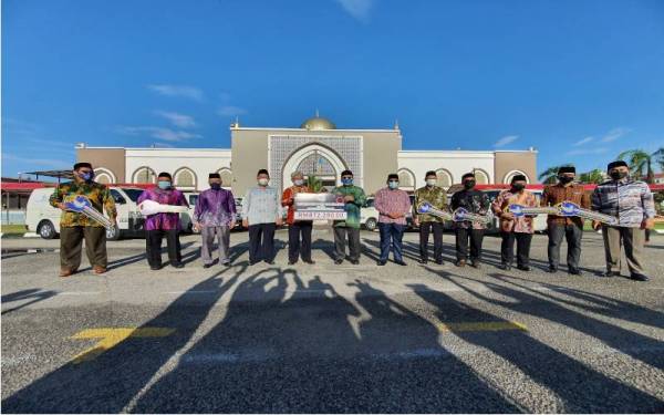 Ahmad Zakiyuddin (lima dari kiri) menerima replika cek sumbangan van jenazah daripada Amran.